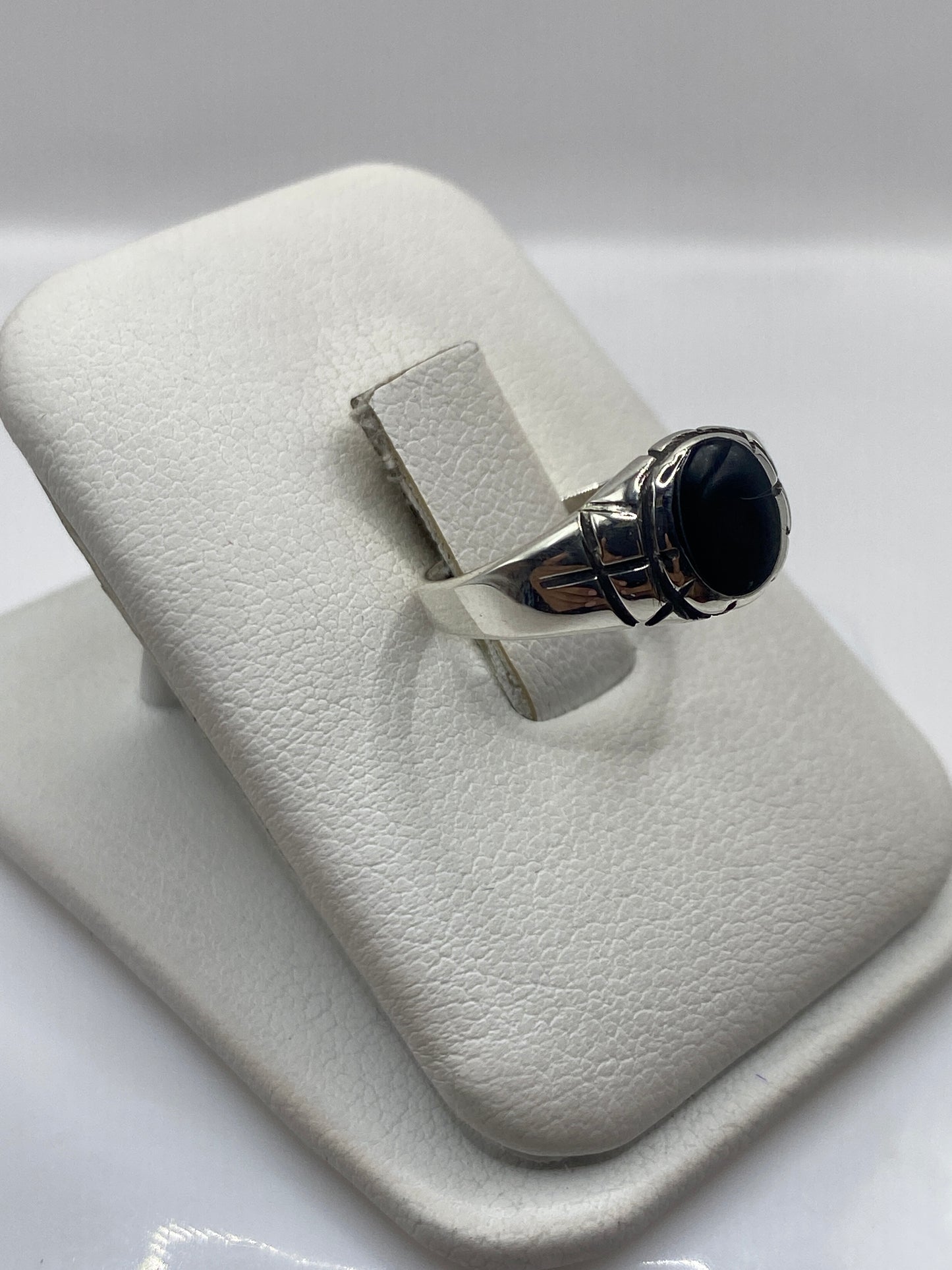 Vista lateral del anillo unisex mostrando el engaste de ónix en plata