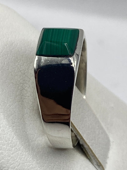 Anillo de malaquita puesto en dedo mostrando vetas naturales de la piedra