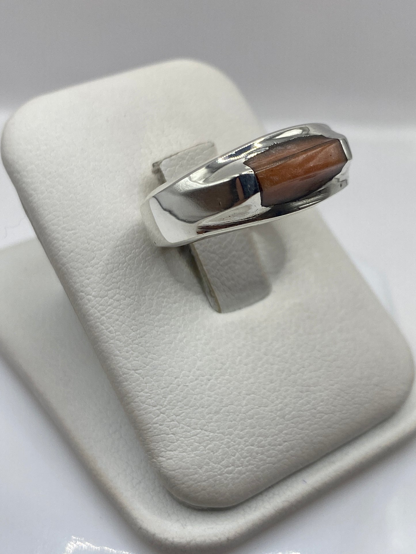 Perfil lateral del anillo moderno mostrando el engaste y la banda de plata