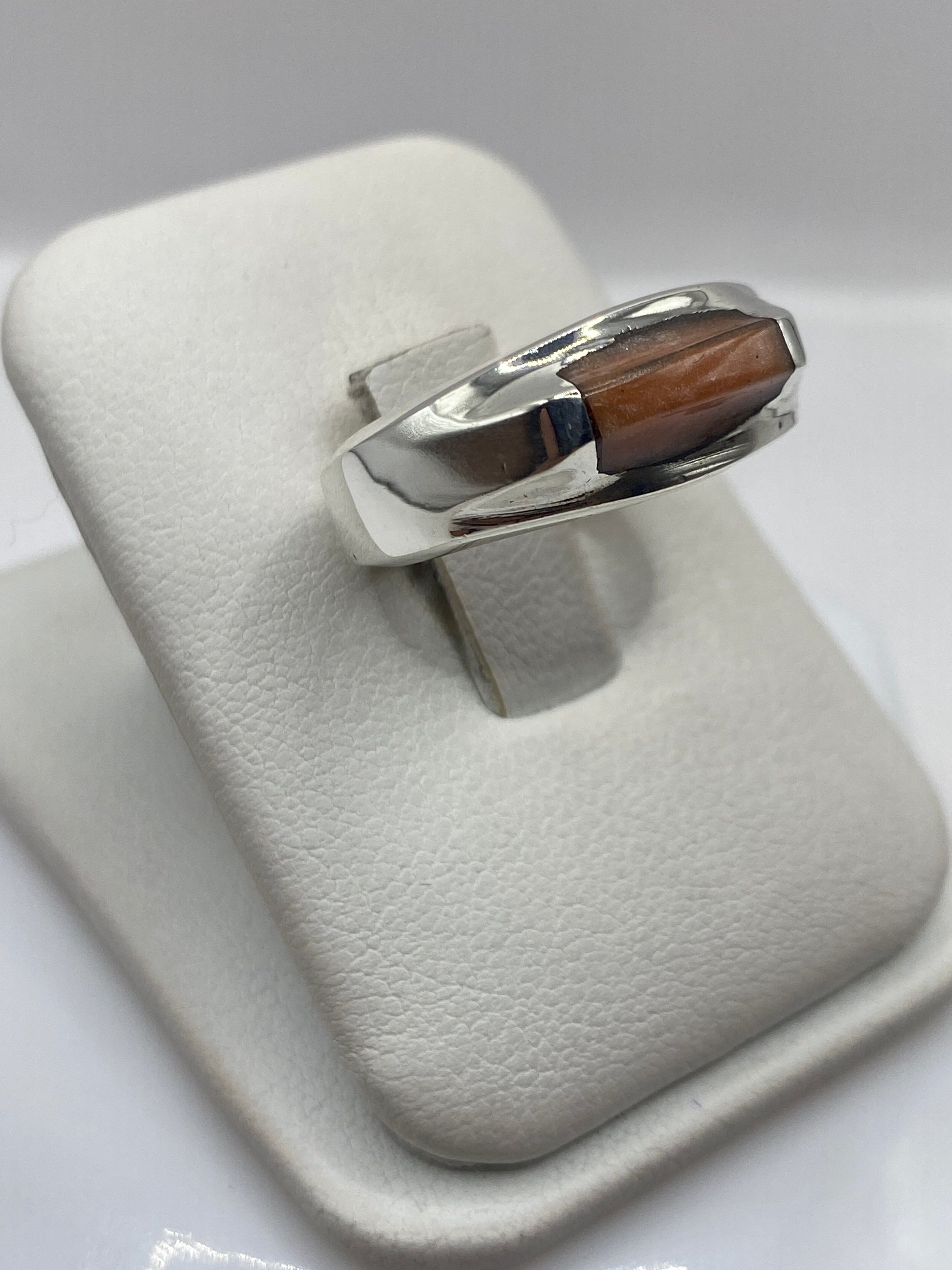 Perfil lateral del anillo moderno mostrando el engaste y la banda de plata