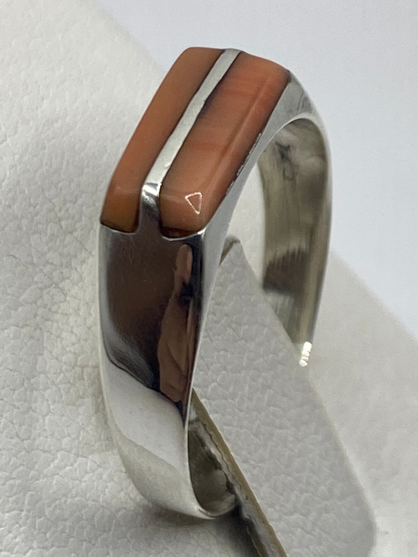 Anillo en la mano de una mujer, detalle del pulido espejo de la plata
