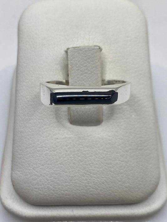 Anillo de plata con ónix negro pulido en mano de persona, diseño minimalista unisex