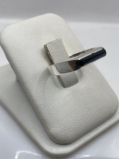 Vista frontal del anillo coctel con piedra de ónix negro rectangular en plata .925