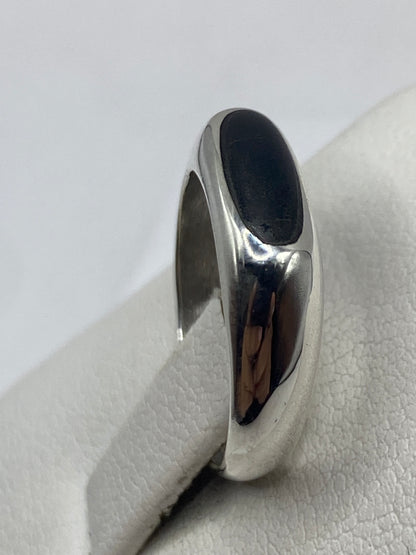 Detalle del ónix negro en plata, fotografía sobre mano con tono de piel medio