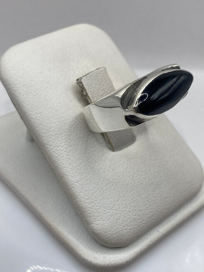 Anillo solitario de plata ónix en la mano, mostrando el engaste pulido