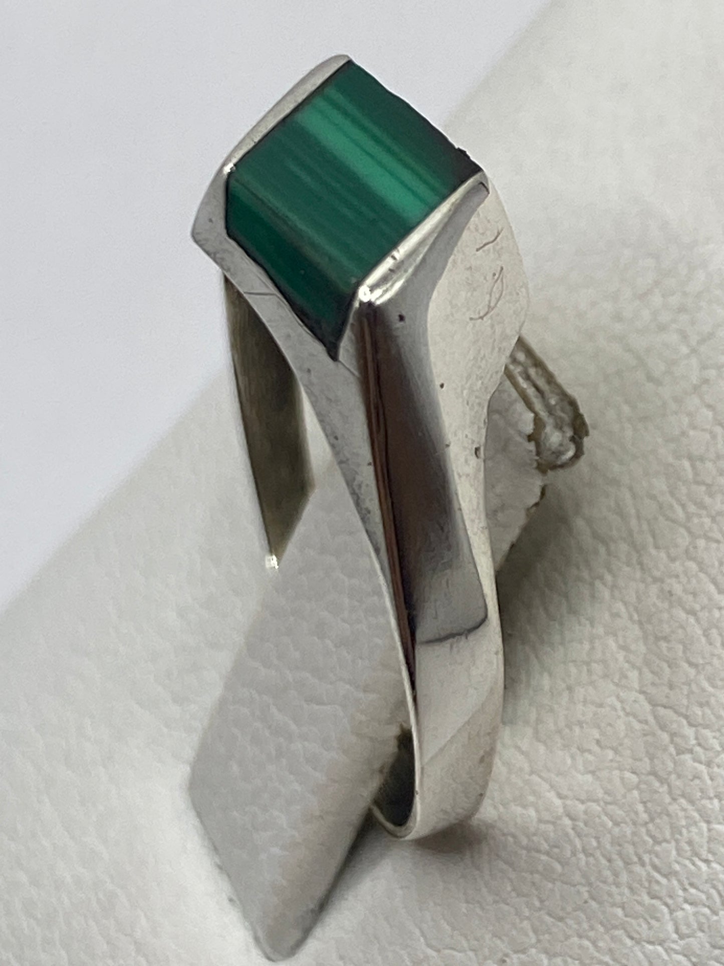 Anillo solitario de plata con malaquita en dedo, mostrando versatilidad y elegancia