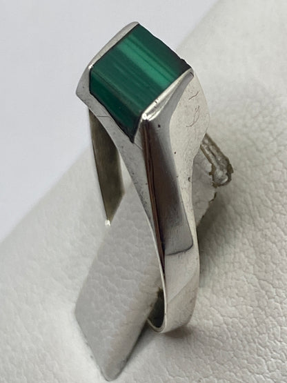 Anillo solitario de plata con malaquita en dedo, mostrando versatilidad y elegancia