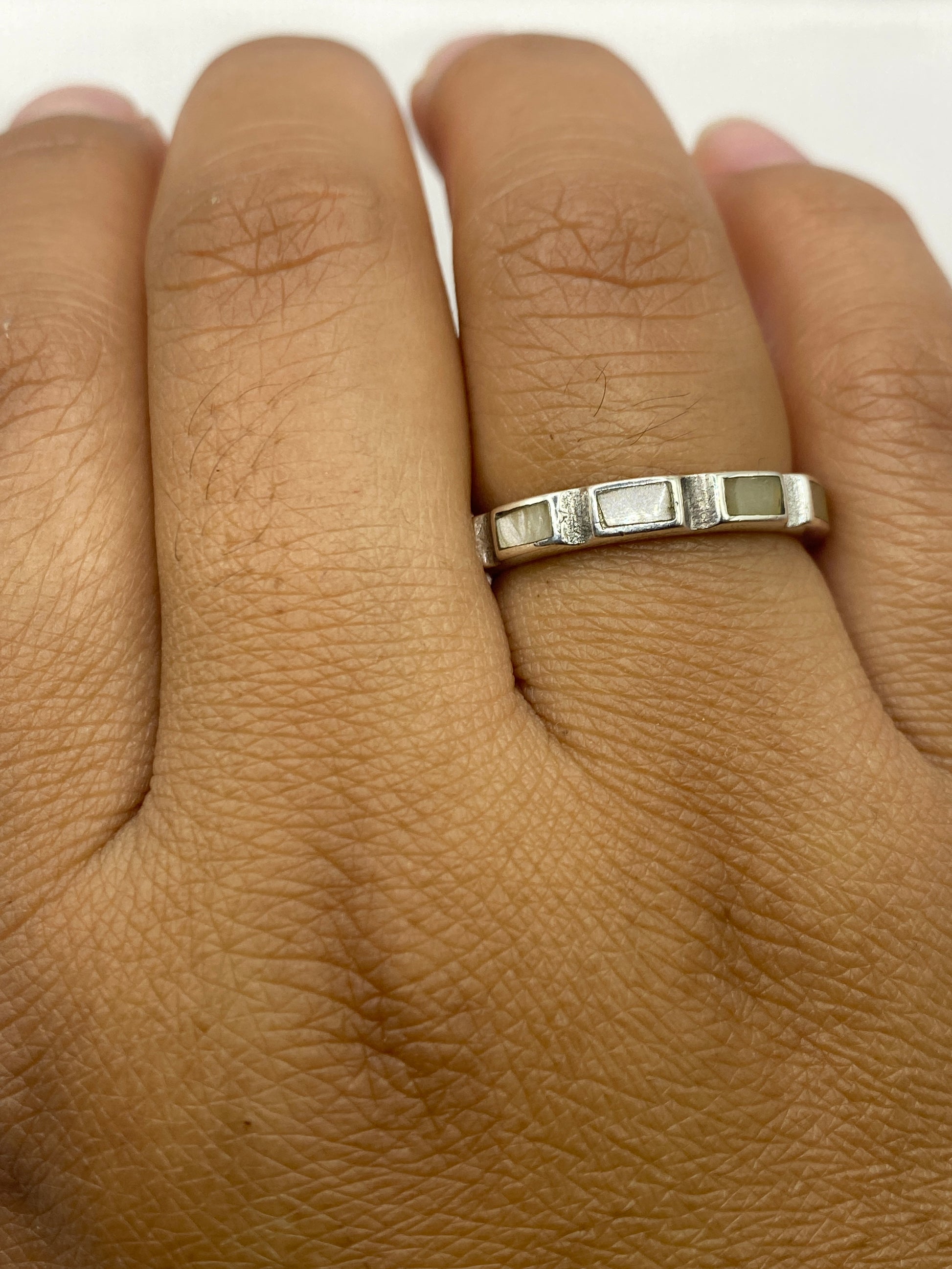 Anillo sobre dedo mostrando el diseño geométrico y la perla natural