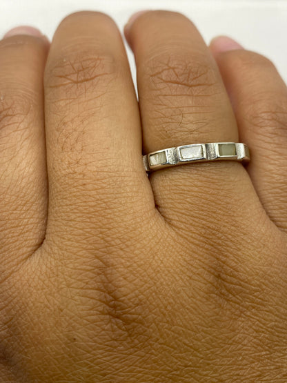 Anillo sobre dedo mostrando el diseño geométrico y la perla natural