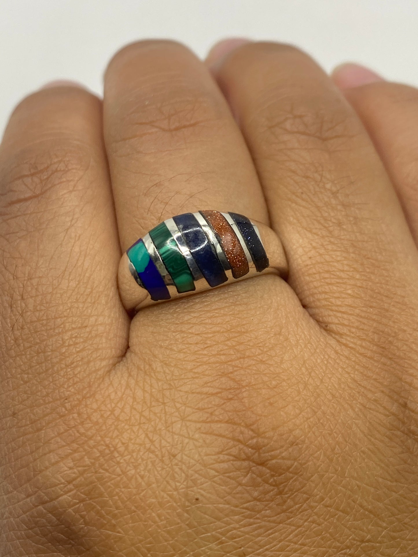 Anillo en dedo mostrando el diseño alternado de plata y malaquita