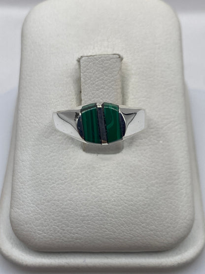 Anillo de plata con malaquita verde natural en la mano de una mujer