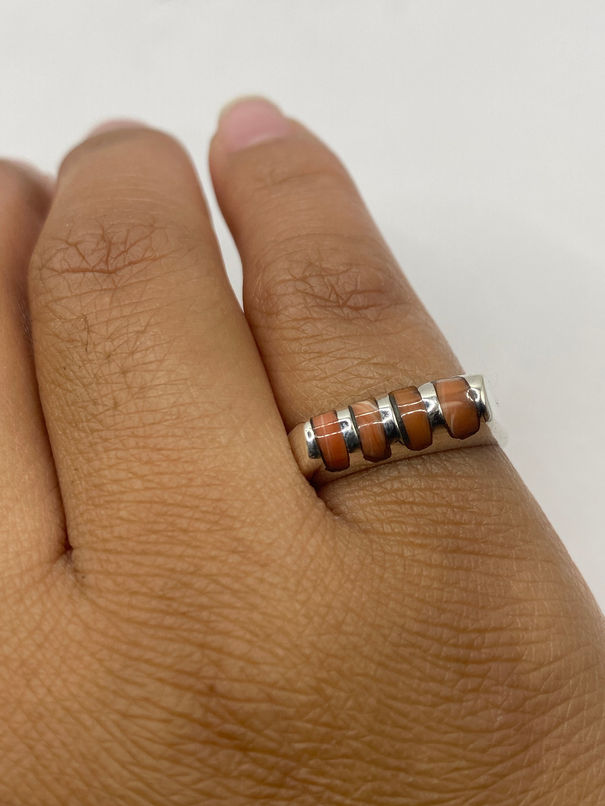 Detalle del anillo solitario sobre fondo gris mostrando el sello .925 de Taxco
