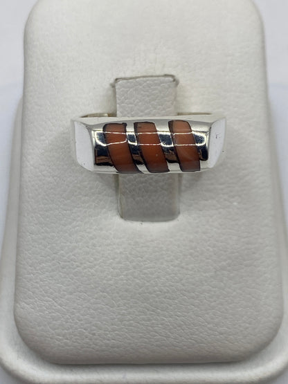 Anillo de plata con coral café cobrizo engastado en eslabones, vista frontal sobre dedo