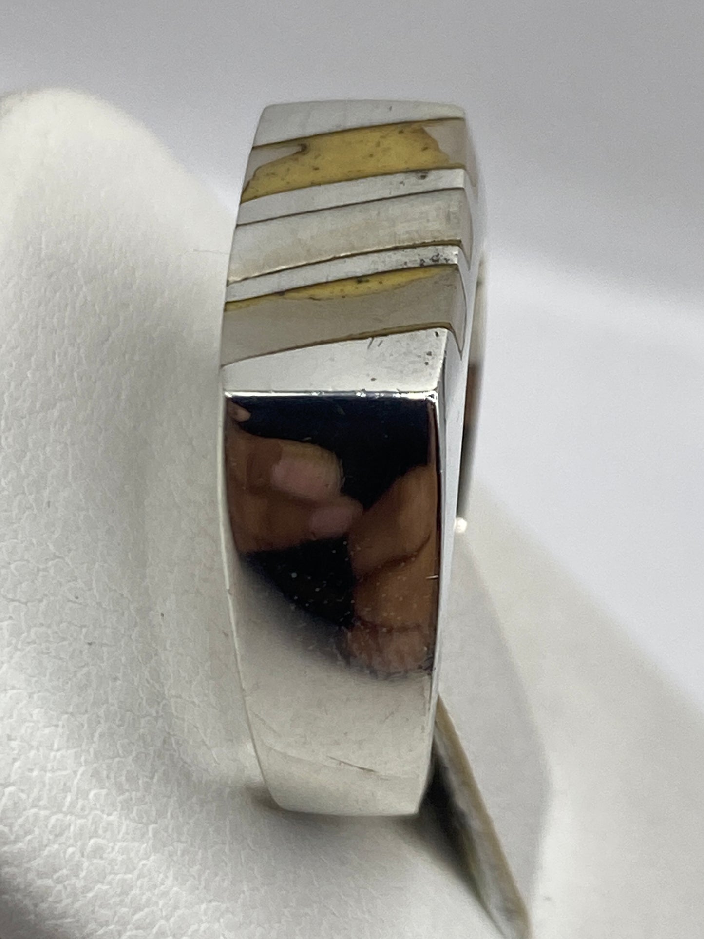 Detalle lateral del anillo en plata .925 con bandas simétricas alrededor de la perla