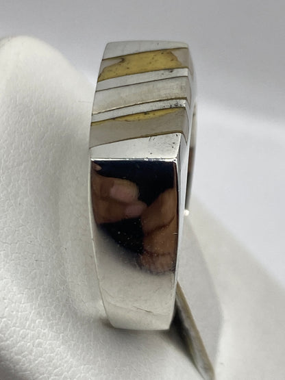 Detalle lateral del anillo en plata .925 con bandas simétricas alrededor de la perla