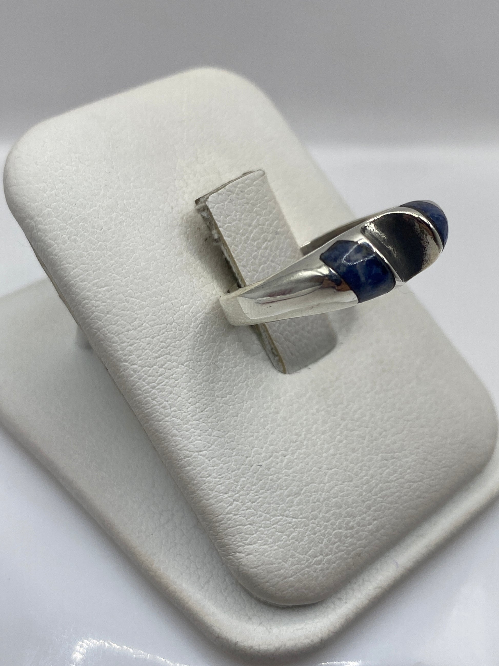 Anillo de lapislázuli en la mano mostrando el color azul profundo y la banda pulida