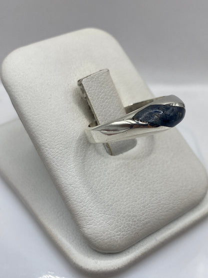 Vista lateral del anillo mostrando el engaste minimalista y el lapislázuli profundo