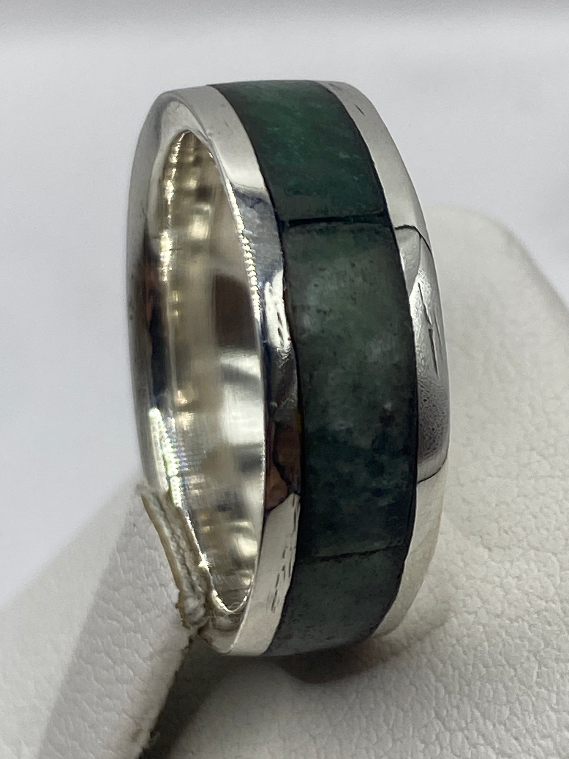 Anillo en la mano mostrando el sello .950 y la presencia unisex de la pieza