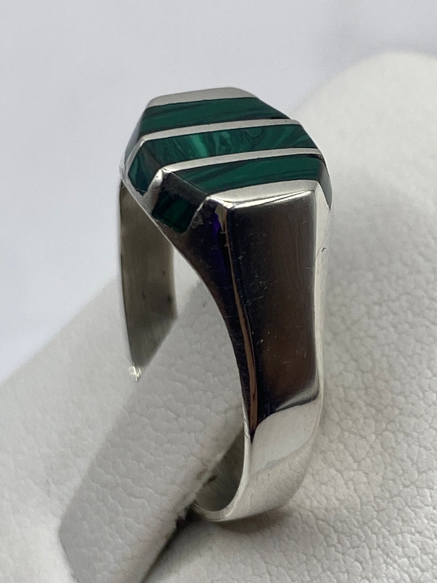 Detalle del anillo de malaquita con bandas de plata plateadas, mostrando vetas verdes naturales
