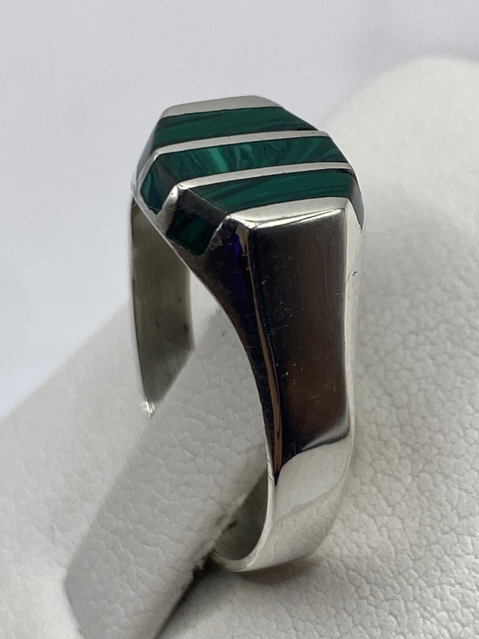 Detalle del anillo de malaquita con bandas de plata plateadas, mostrando vetas verdes naturales