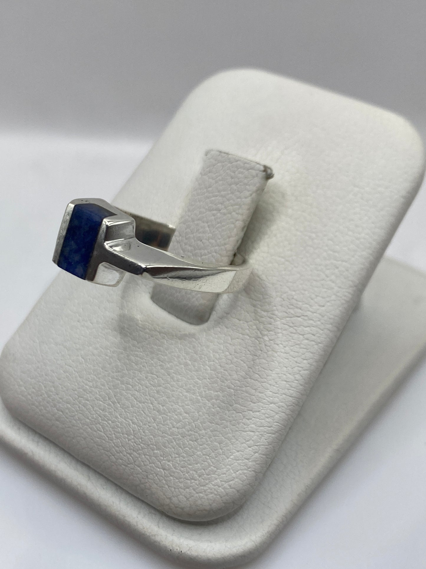 Anillo solitario de lapislázuli en la mano, mostrando el color azul profundo