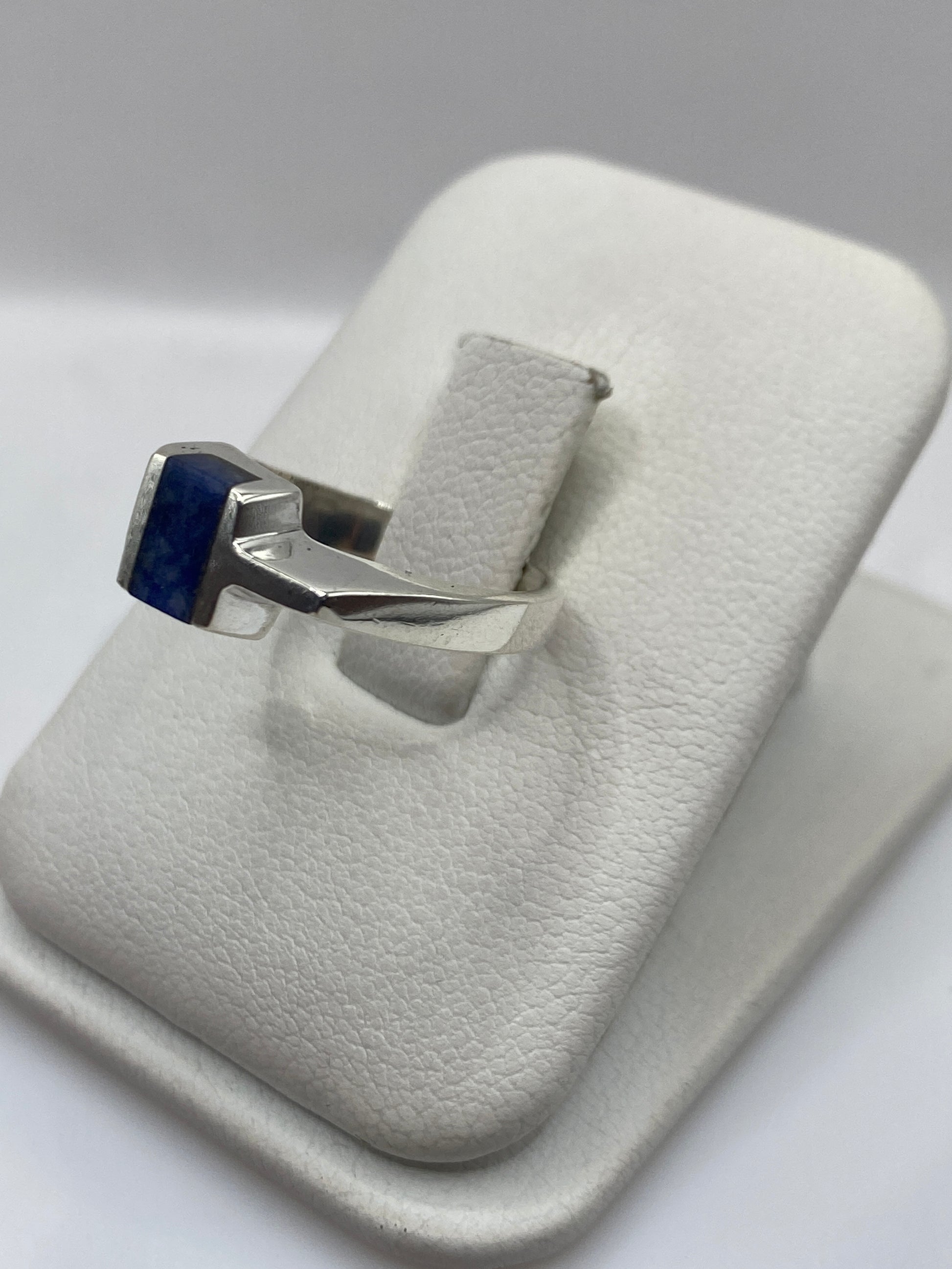 Anillo solitario de lapislázuli en la mano, mostrando el color azul profundo