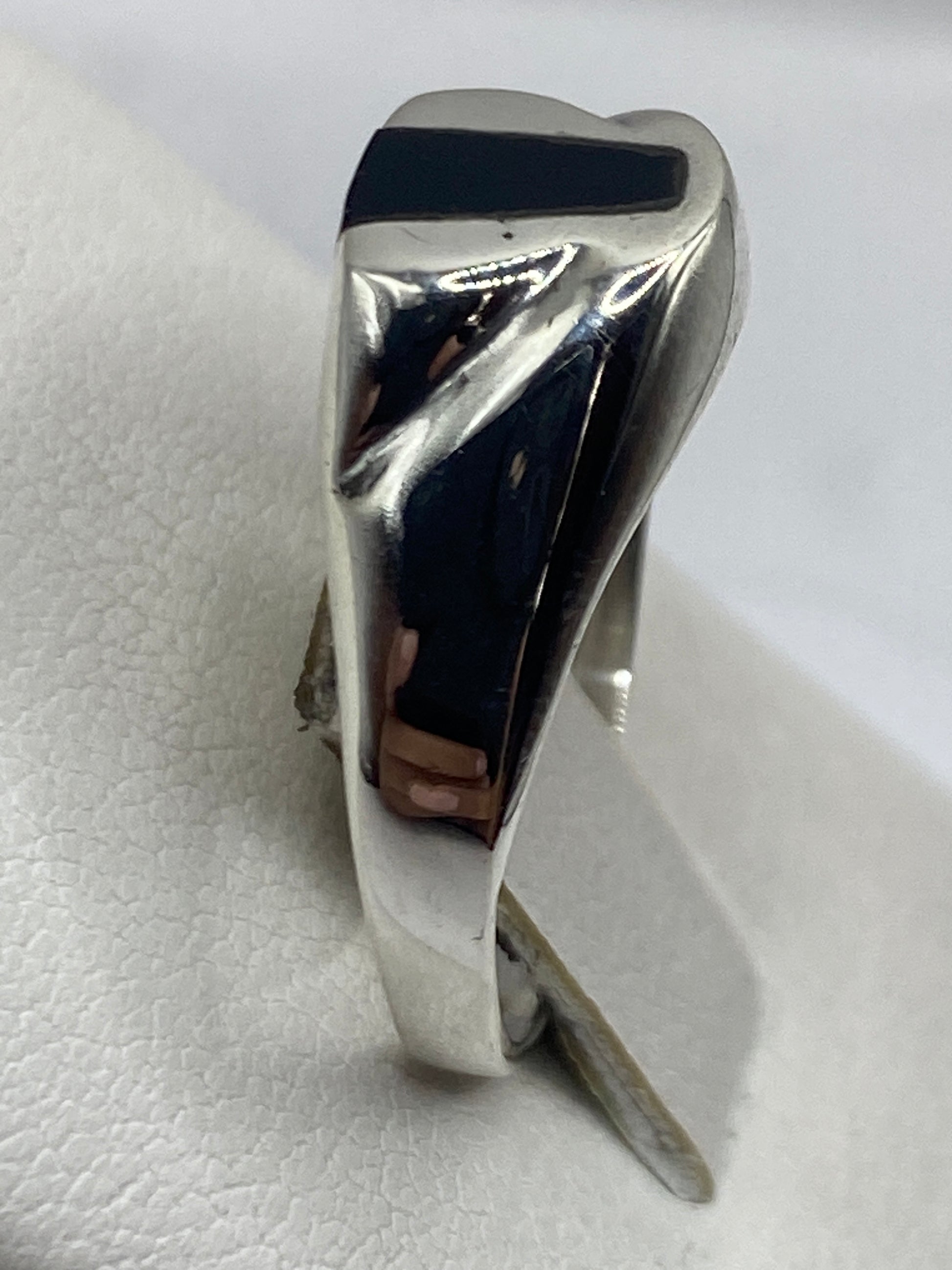Anillo de ónix negro en la mano, detalle del pulido espejo de la piedra