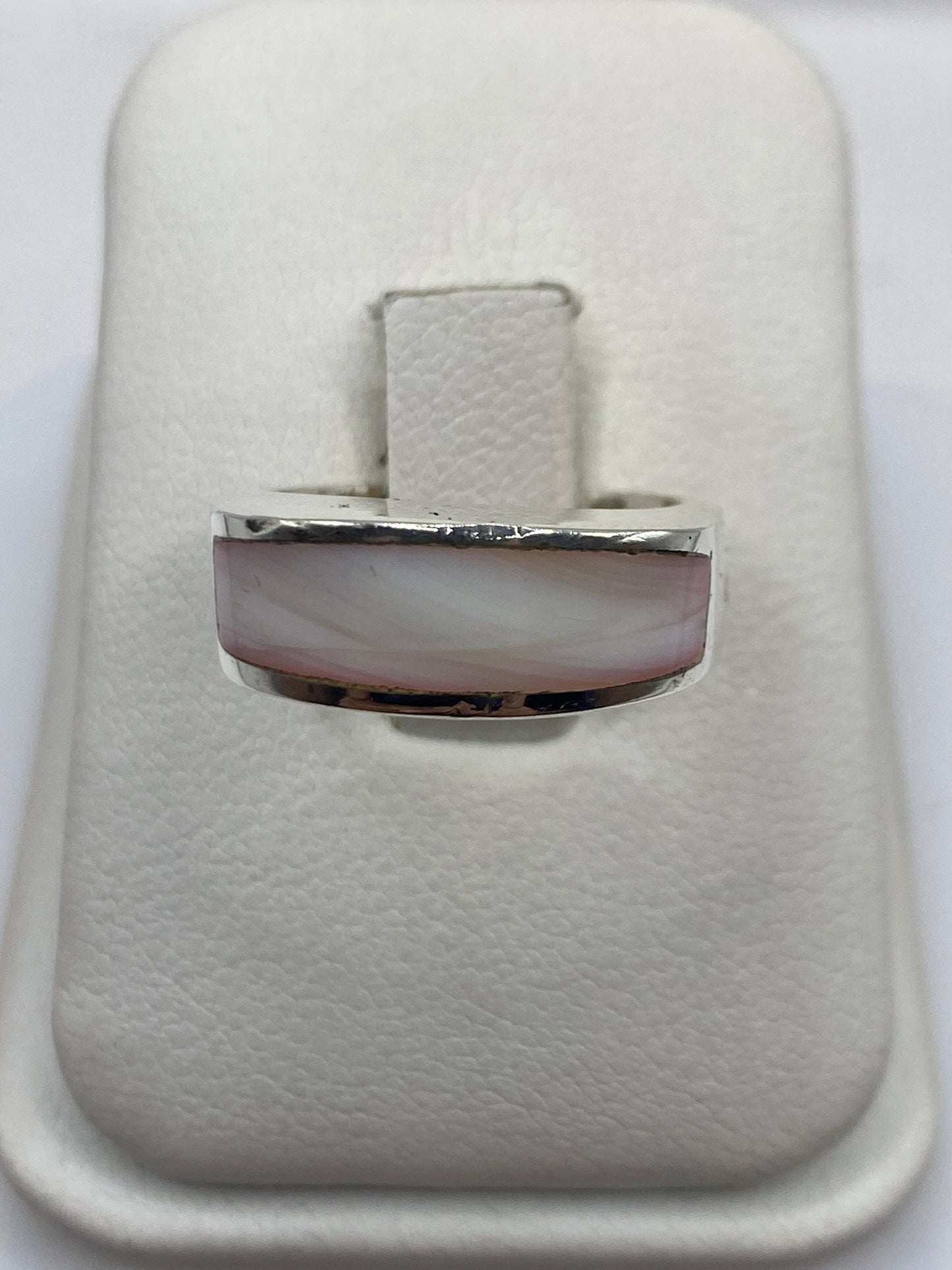 Anillo de plata solitario con piedra rosa pálida en banda pulida, vista frontal