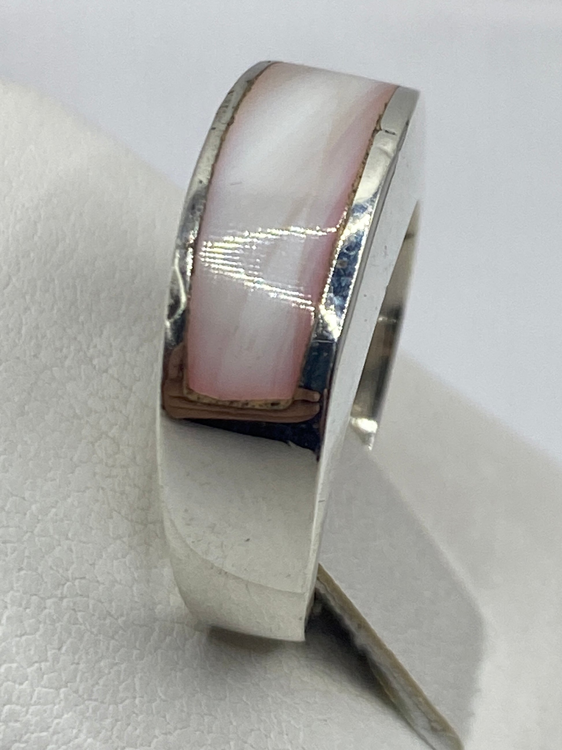 Anillo de plata en la mano de una mujer, piedra rosa natural engastada