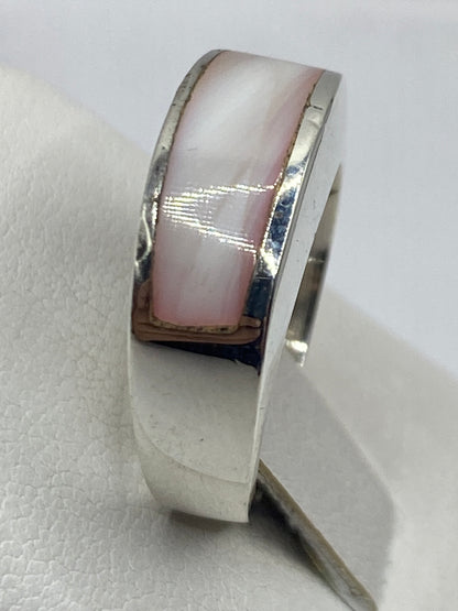 Anillo de plata en la mano de una mujer, piedra rosa natural engastada
