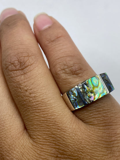Anillo unisex en dedo mostrando el brillo iridiscente de la piedra natural