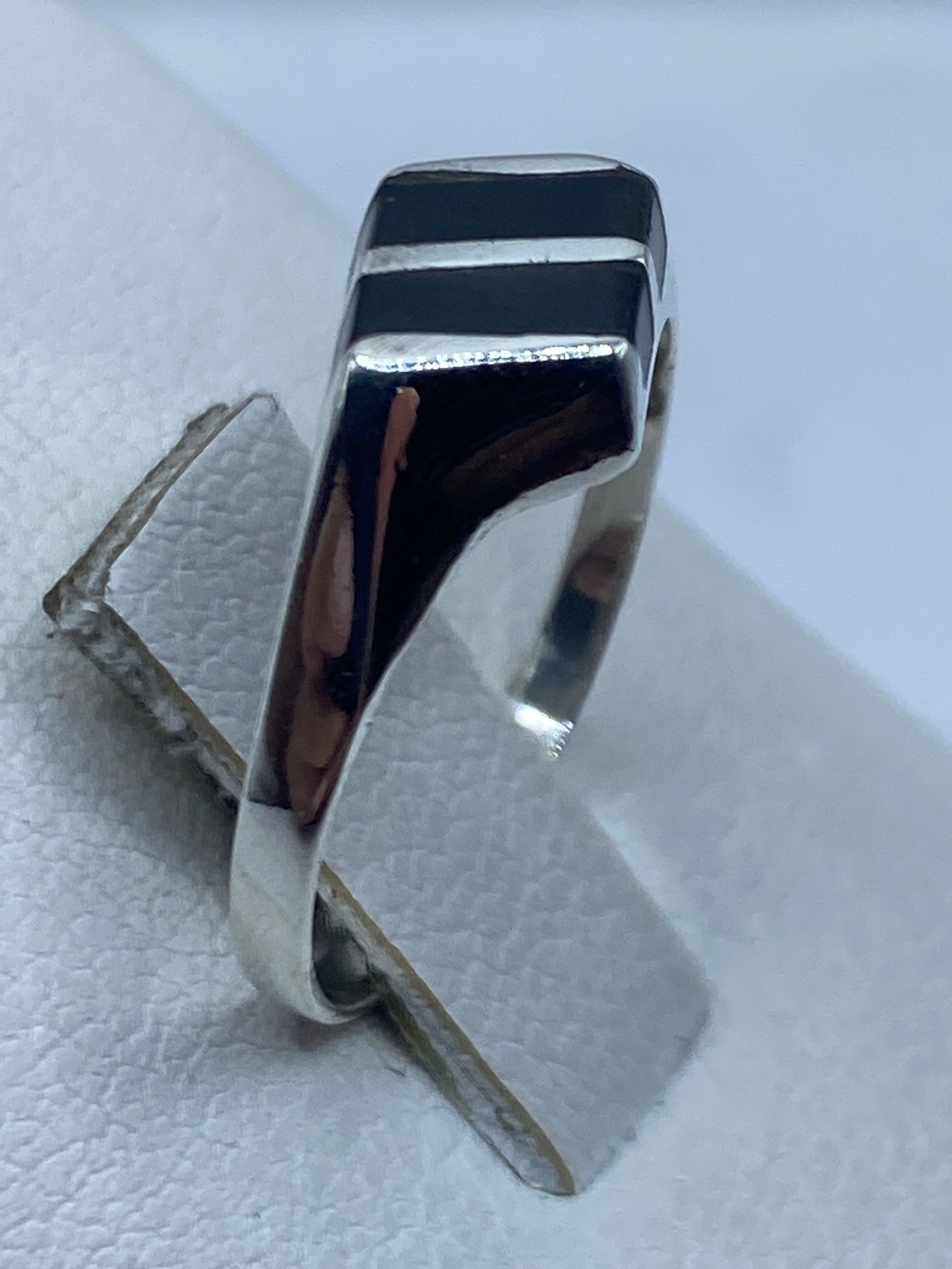 Anillo unisex de onix negro sobre dedo con acabado pulido brillante