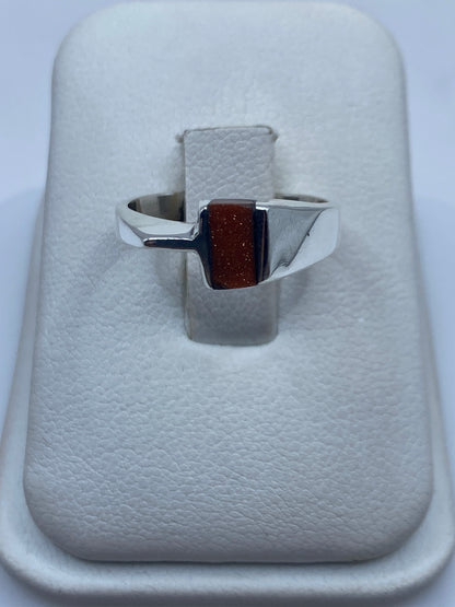 Anillo de plata .925 con piedra natural rectangular en tono marrón rojizo, vista frontal sobre fondo blanco