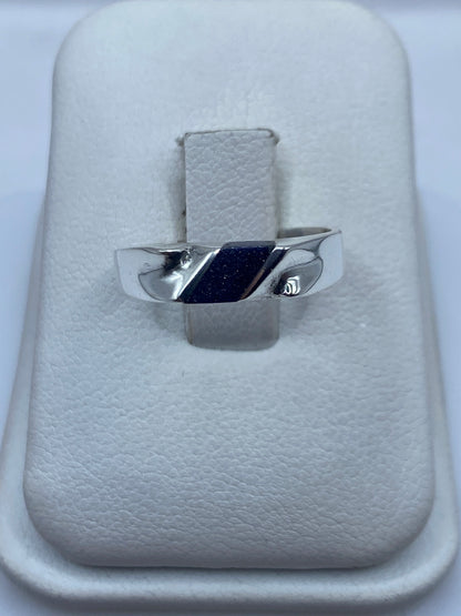 Anillo de plata .925 con piedra morada engastada, sobre cojín blanco