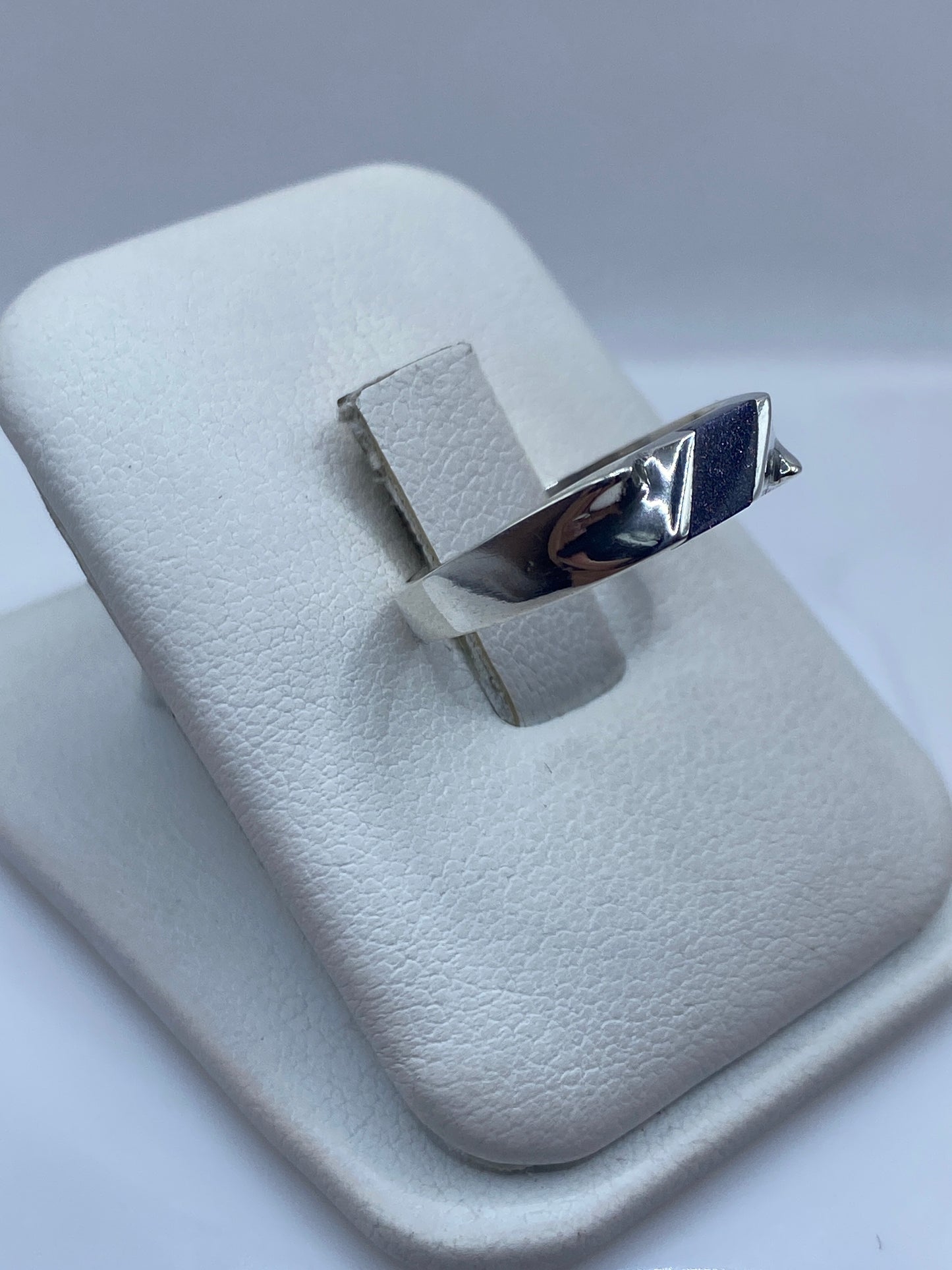 Vista lateral del anillo moderno de plata con detalle del engaste de piedra