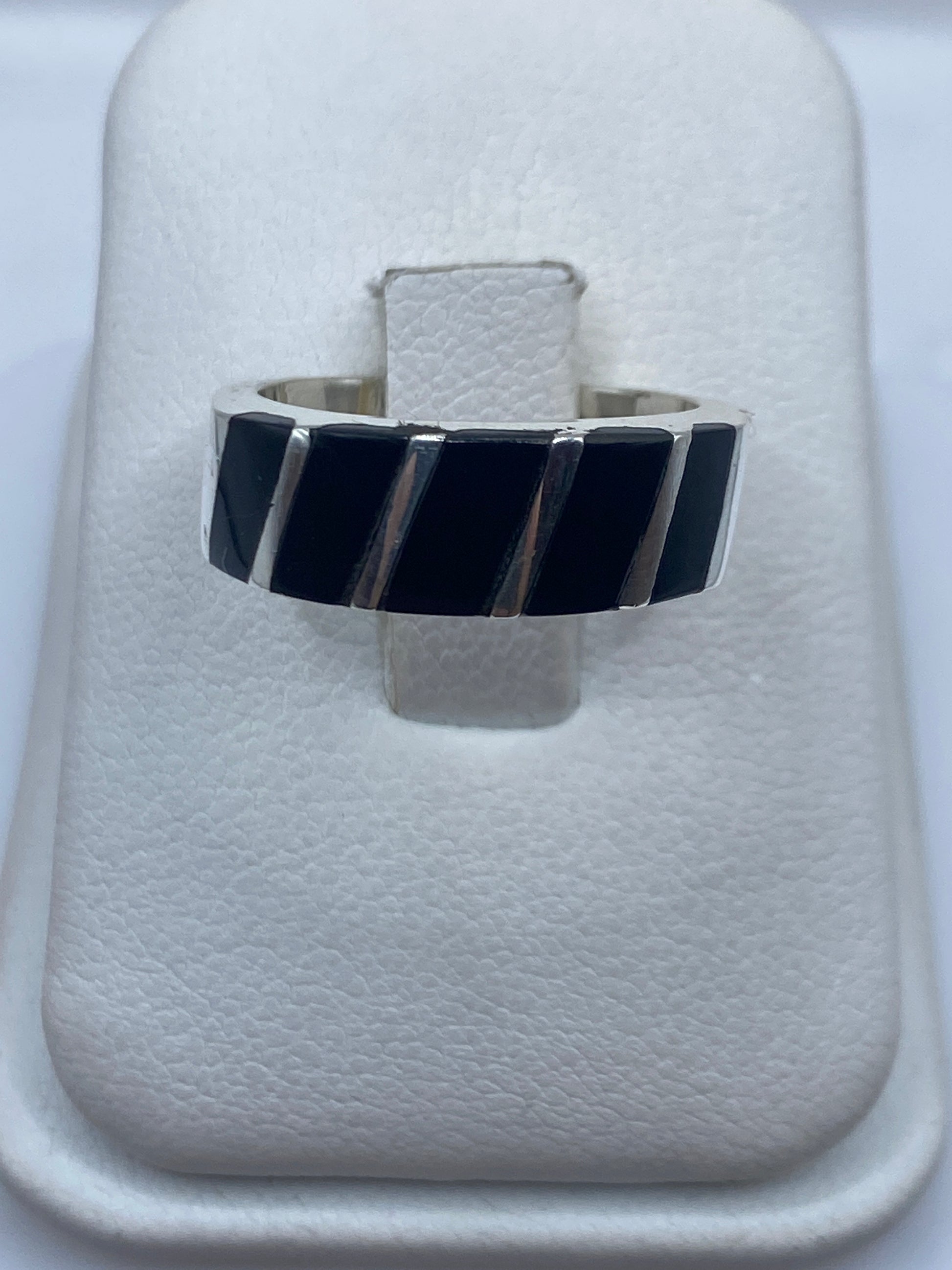 Anillo de plata con ónix negro en patrón geométrico sobre dedo índice