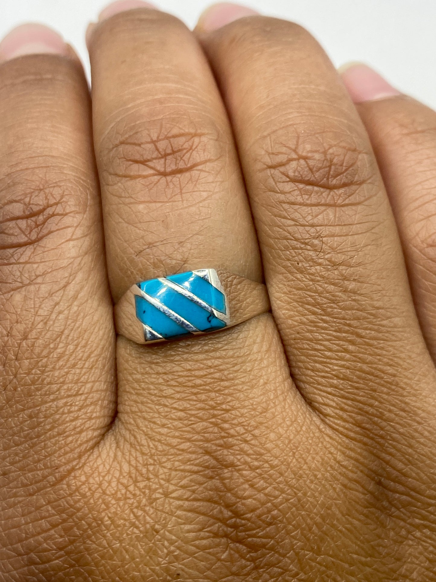 Anillo en dedo mostrando cómo se lleva la turquesa con elegancia minimalista, con sello .925 MEXICO visible en banda interior