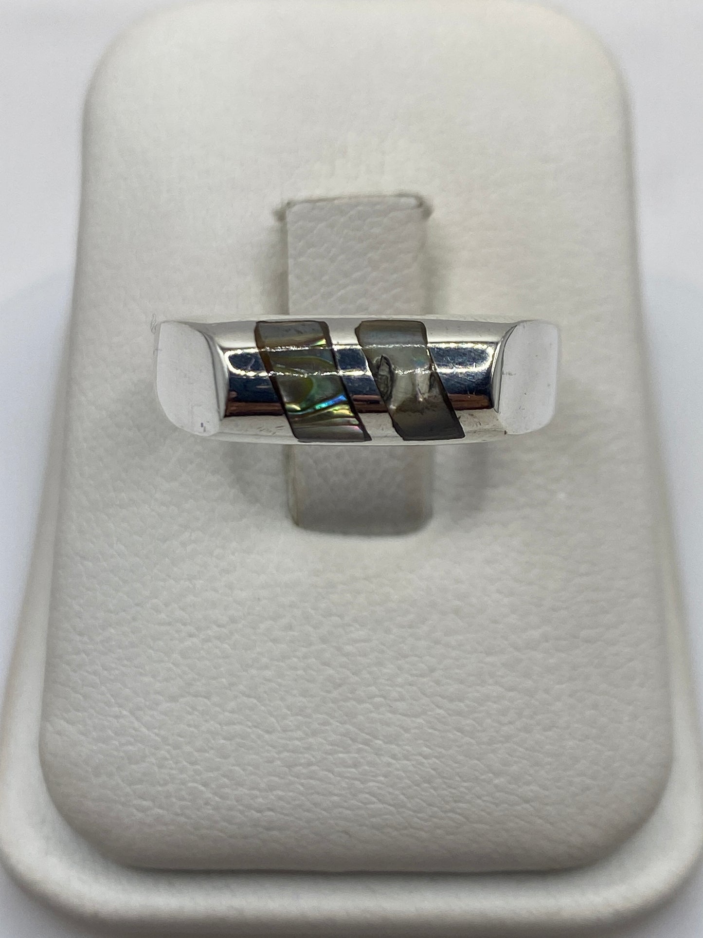 Anillo solitario de plata .925 con piedra engastada, visto de frente sobre estuche blanco