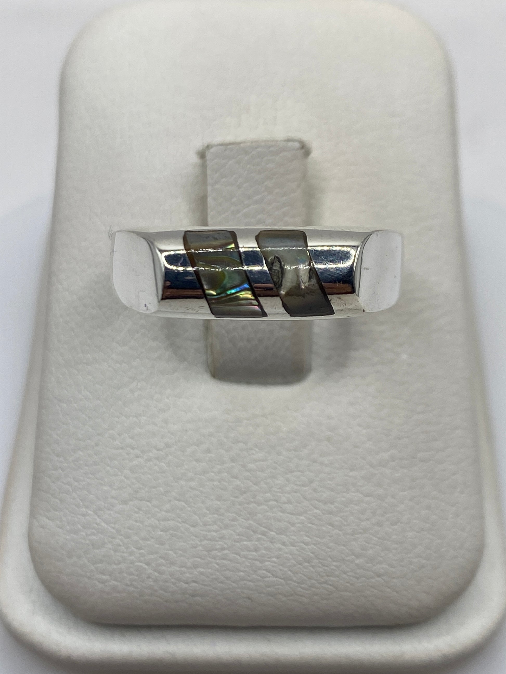 Anillo solitario de plata .925 con piedra engastada, visto de frente sobre estuche blanco