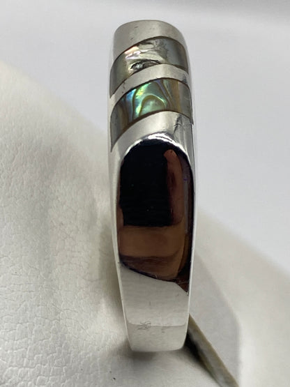 Detalle del anillo solitario con piedra capturando la luz, mostrando el pulido espejo de la plata