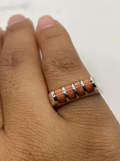 Anillo de coral en plata sobre fondo gris mostrando el sello 925