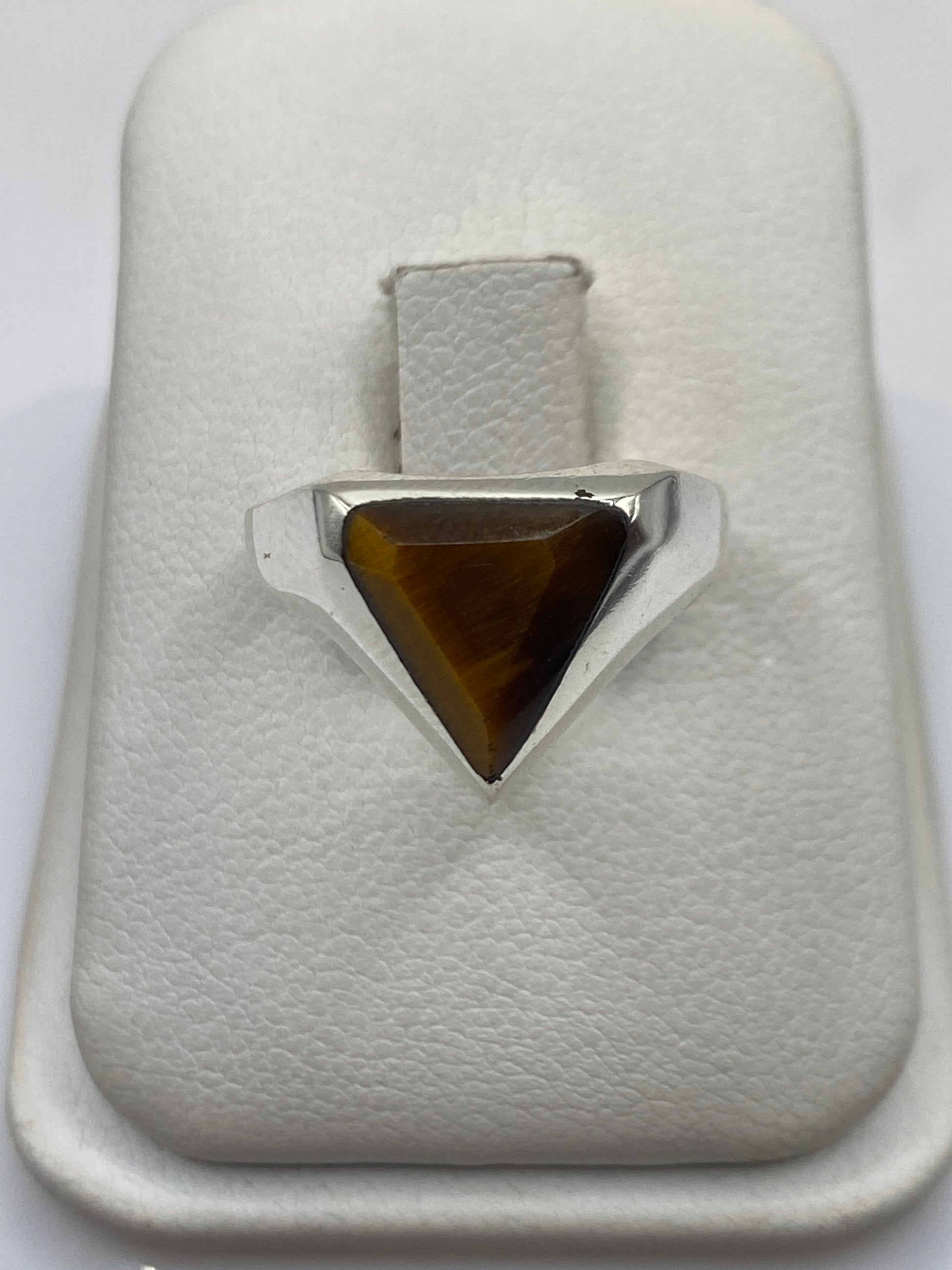 Anillo de plata solitario con piedra café natural en la mano de una mujer
