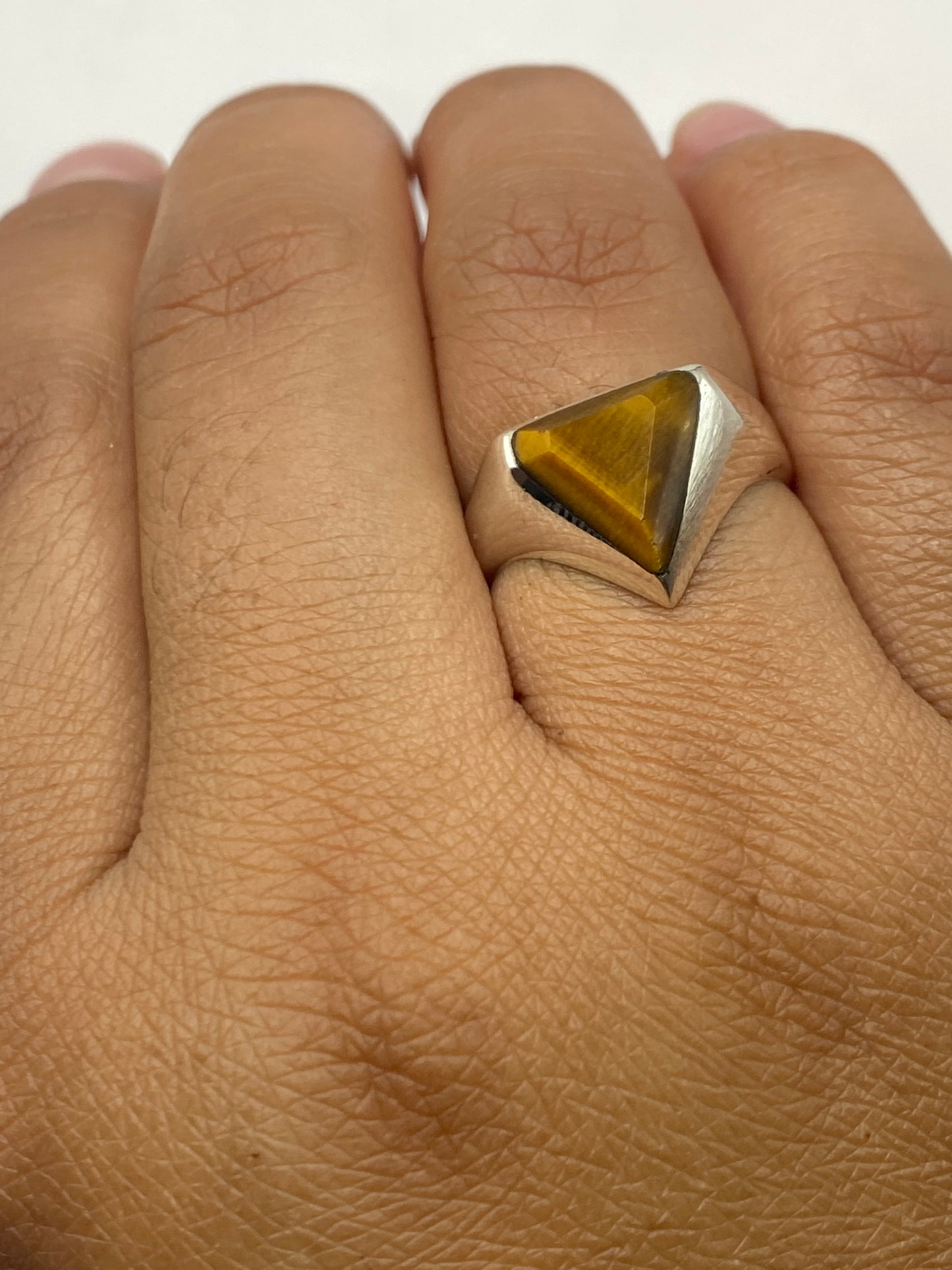 Anillo sobre fondo blanco mostrando la profundidad y brillo de la piedra café