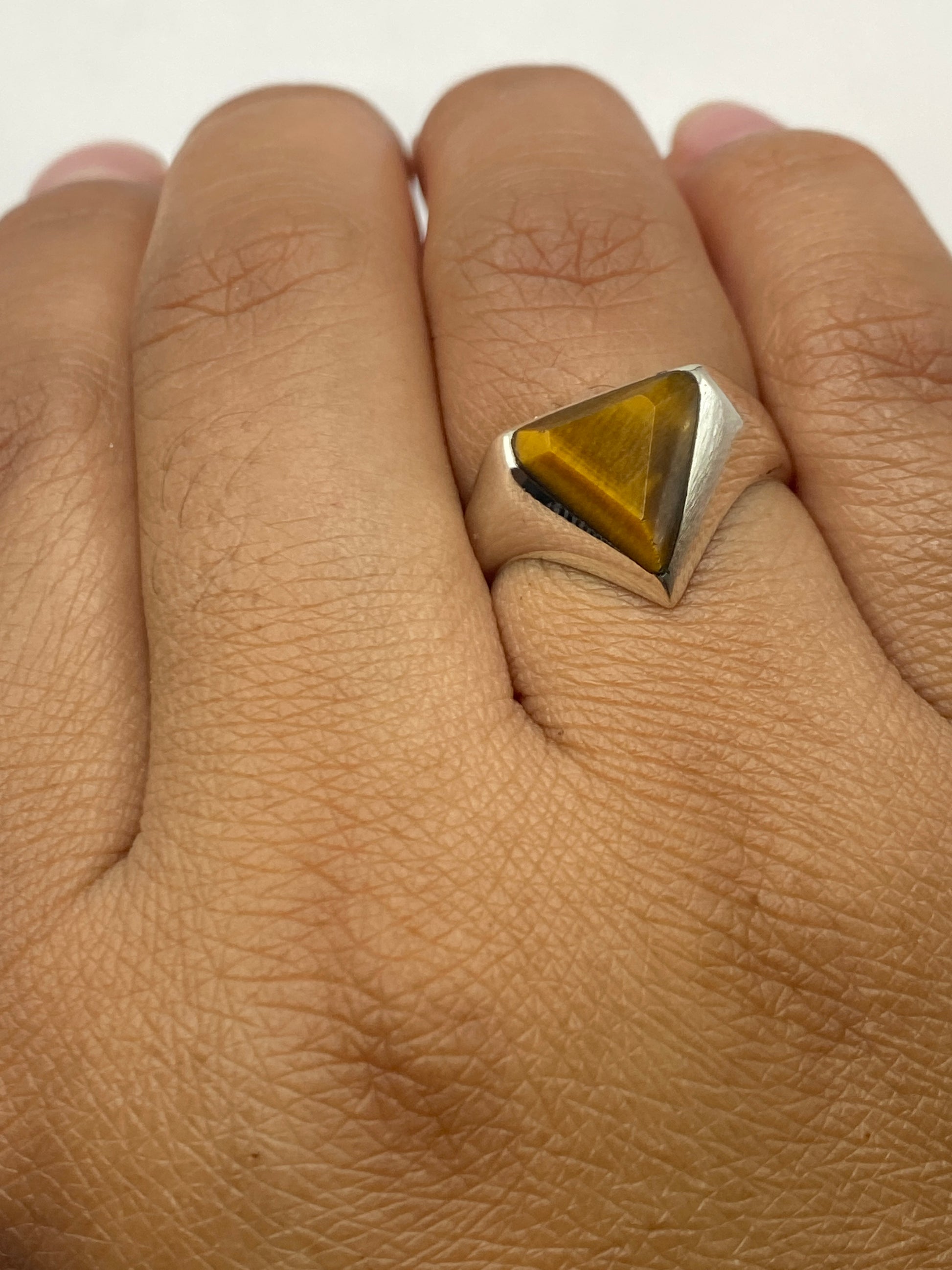 Anillo sobre fondo blanco mostrando la profundidad y brillo de la piedra café