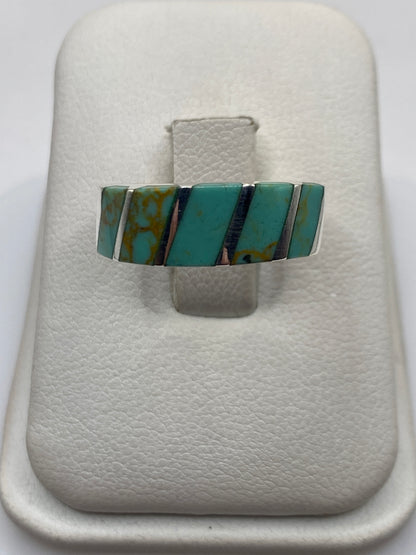 Anillo de plata con turquesa azul cielo en bandas geométricas, sobre blanco