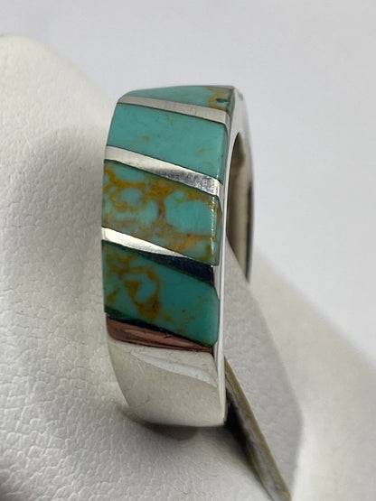 Anillo étnico de turquesa puesto en dedo, mostrando el brillo de la piedra