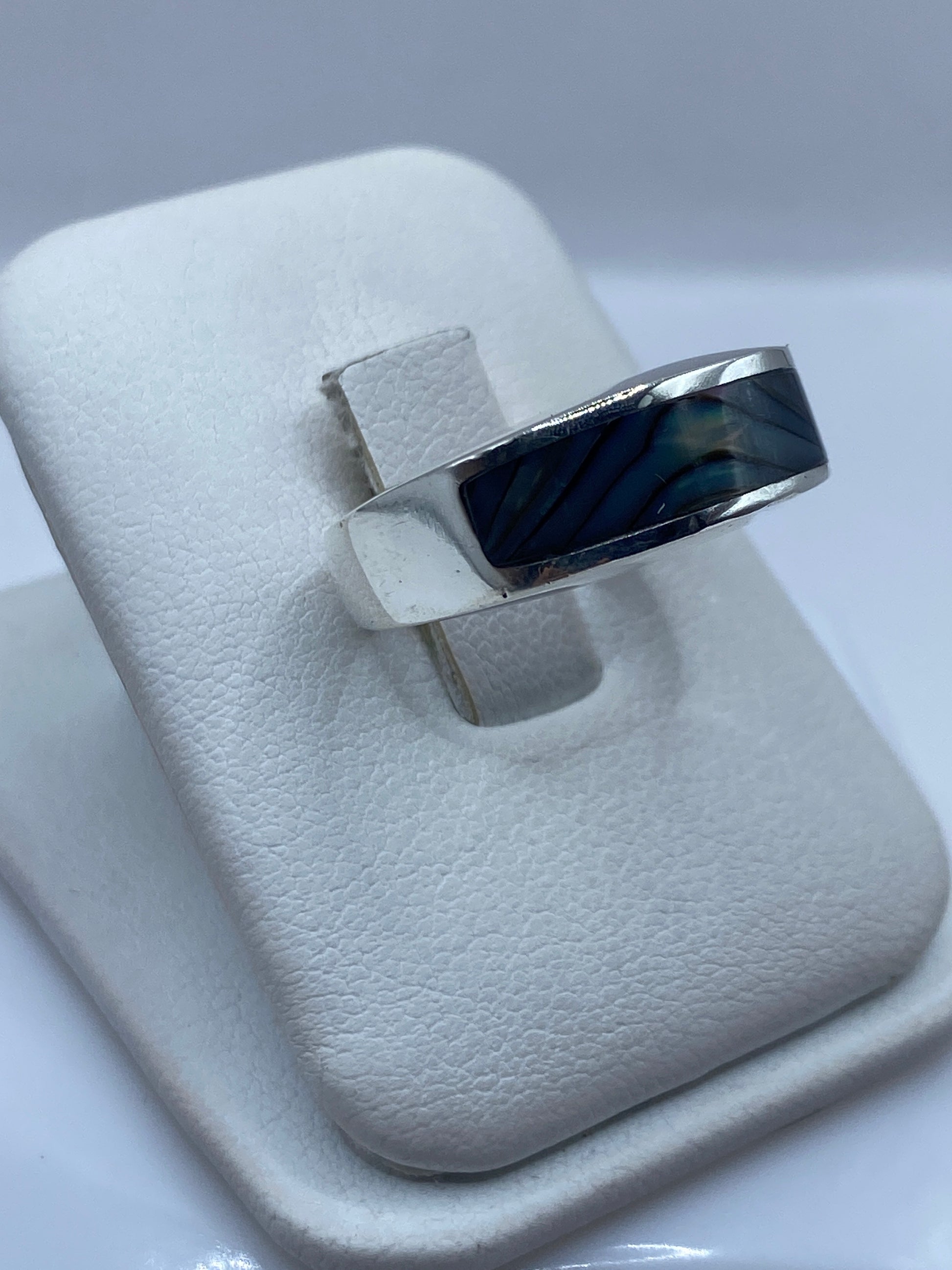 Detalle lateral del anillo minimalista mostrando el perfil geométrico y peso de la plata