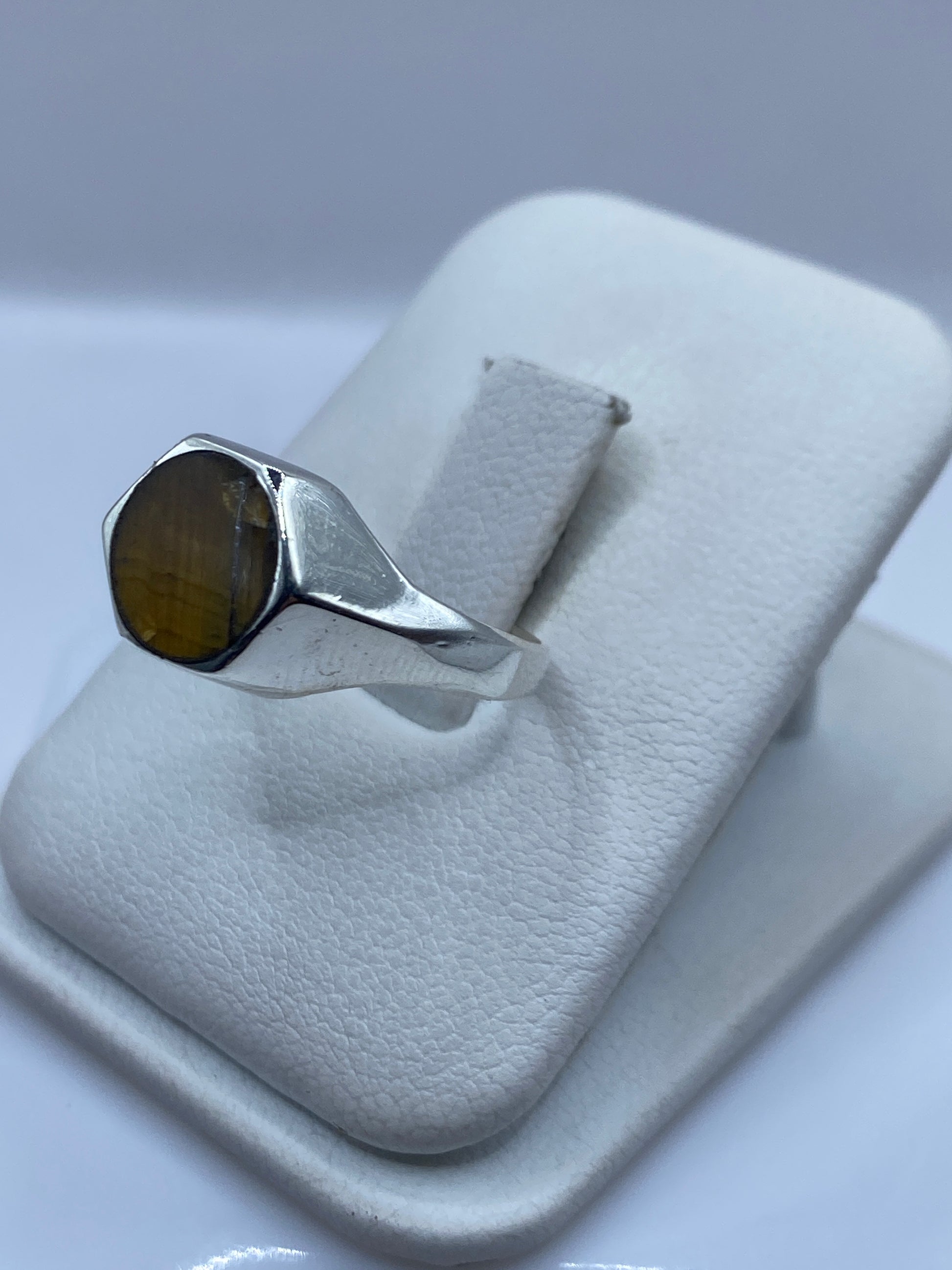 Detalle lateral del anillo solitario mostrando engaste a mano y banda de plata