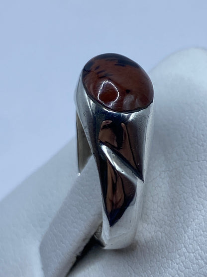 Anillo solitario en la mano mostrando el brillo de la piedra y la banda asimétrica
