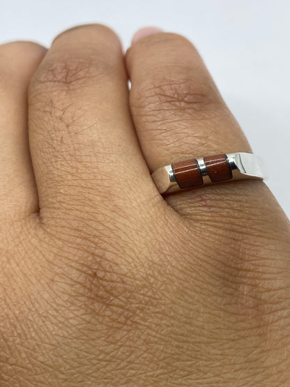Anillo colocado sobre fondo gris mostrando el brillo de la piedra natural